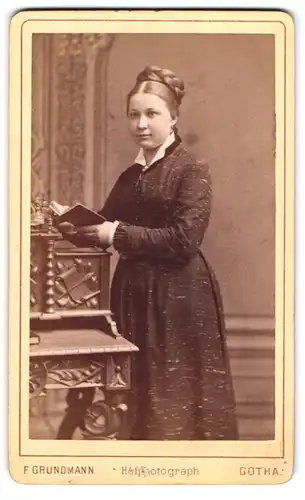 Fotografie Ferd. Grundmann, Gotha, Löwenstr. 9, Junge Dame im Kleid mit Buch