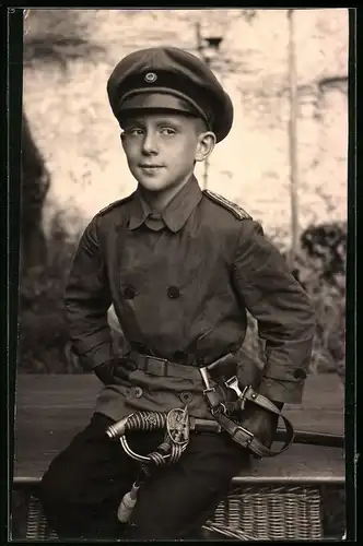 Fotografie 1.WK, Knabe in Uniform mit Offiziers-Degen & Schirmmütze
