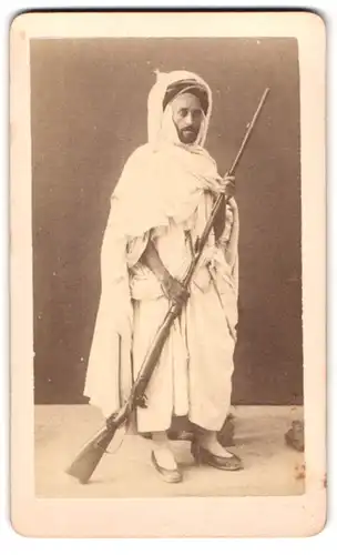 Fotografie unbekannter Fotograf und Ort, Beduinen Krieger im Thawb mit Beduinenflinte