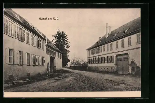 AK Hürtigheim /U.-E., Strassenpartie mit zwei Gebäuden mit Tor