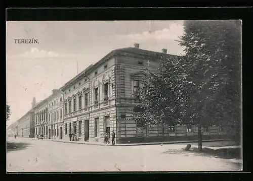 AK Terezín, Strassenpartie mit Eckgebäude und Passanten