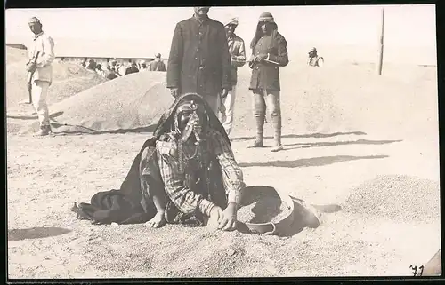 Fotografie afrikanische Volkstypen, Beduinen-Frau in Tracht siebt Sand aus