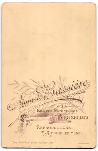 Fotografie A. Bassiere, Bruxelles, junges Paar im Anzug mit Zylinder und Frau im Kleid mit Federboa und Federhut