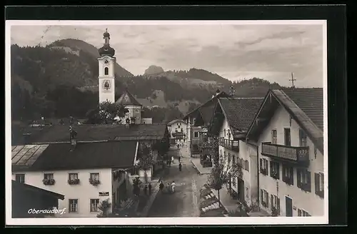 AK Oberaudorf, Strassenpartie mit Passanten und Kirche