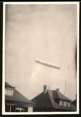 Fotografie Zeppelin - Luftschiff über Wohnhäusern