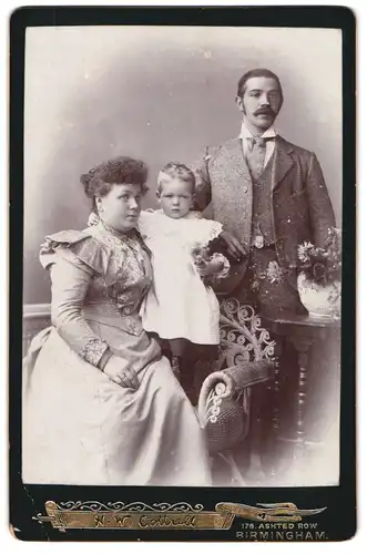 Fotografie H. W. Cottrell, Birmingham, Ashted Row 176, Ernst blickendes junges Paar mit kleinem Sohn im Kleidchen