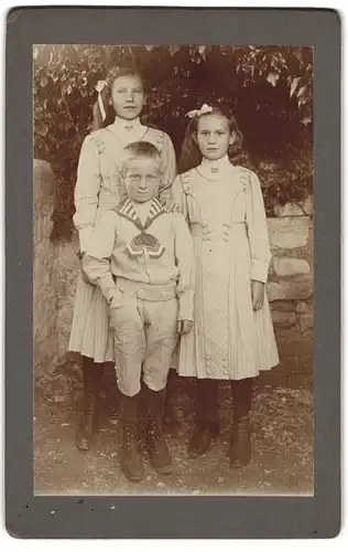 Fotografie J. Baldi, Peseux, Zwei Mädchen in Sonntagskleidern und ein Knabe im Matrosenanzug