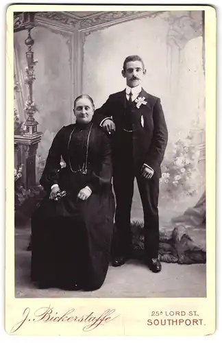 Fotografie J. Bickerstaffe, Southport, Lord Street 25a, Korpulente Dame mit Mittelscheitel und Herr mit Schnurrbart