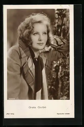 AK Schauspielerin Greta Garbo steht vor einem Baumstamm