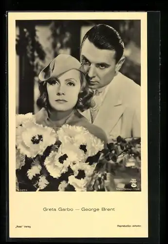 AK Schauspielerin Greta Garbo und Schauspieler George Brent in feinen Kleidern mit Blumen