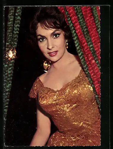 AK Schauspielerin Gina Lollobrigida im goldgelben Spitzenkleid schaut hinter einem Vorhang hervor