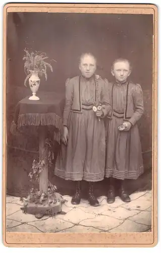 Fotografie unbekannter Fotograf und Ort, zwei junge Mädchen in dunklen Kleidern mit geflochtenem Zopf