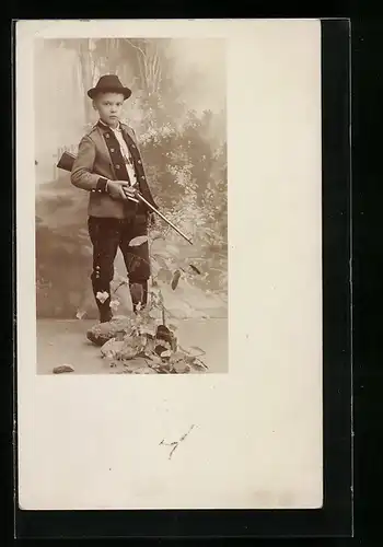 Foto-AK Kleiner Jäger mit Gewehr vor Studiokulisse