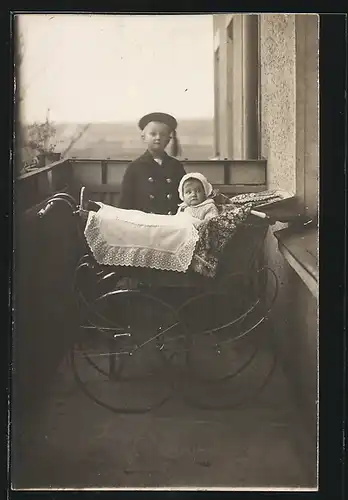 AK Bube steht an einem Kinderwagen auf dem Balkon