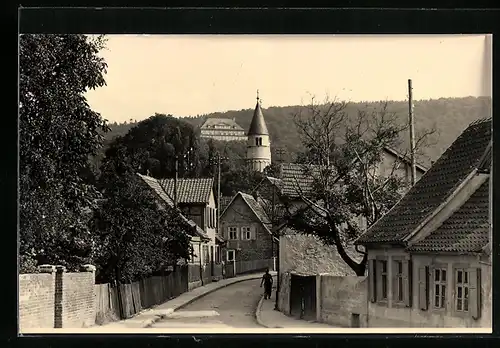 AK Gernrode /Harz, Schmale Strasse mit Wohnhäusern und Blick zur Kirche