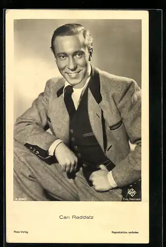 AK Schauspieler Carl Raddatz lächelnd mit aufgestützem Bein