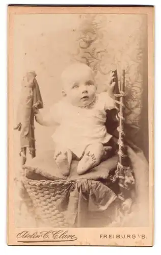 Fotografie C. Clare, Freiburg i. B., Süsses Kleinkind im Hemd mit nackigen Füssen