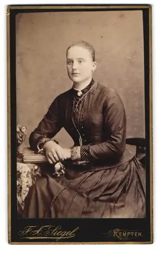 Fotografie F. X. Siegel, Kempten, Kotternerstr., Junge Frau in schwarzem Kleid mit Kreuzkette und Blume