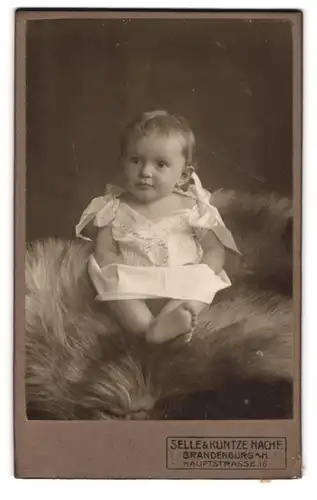 Fotografie Selle & Kuntze Nachf., Brandenburg a. H., Hauptstrasse 16, Süsses Baby in weissem Kleid mit hellen Haaren
