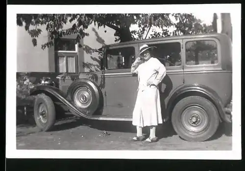 Fotografie Auto, Dame mit Hut neben Limousine stehend