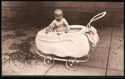 Fotografie Otto Köhler, Berlin, niedliches Baby im Kinderwagen stehend