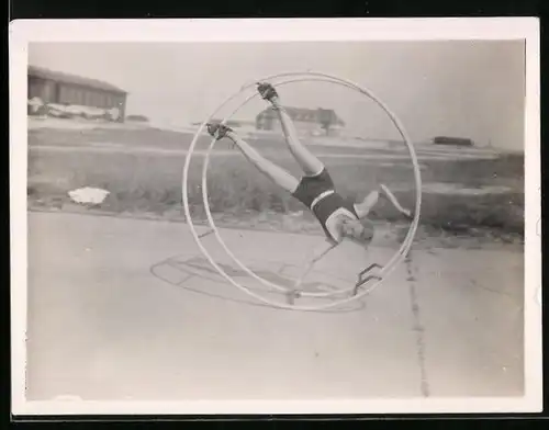 Fotografie hübsche schlanke Frau turnt kopfüber mit einem Rhönrad