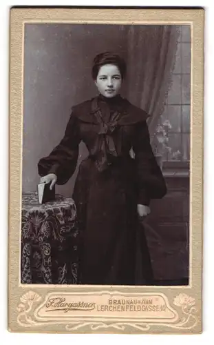 Fotografie F. Hargassner, Braunau a. Inn, Lerchenfeldgasse 10, Junge Frau in schwarzem Kleid mit Schleife und Buch