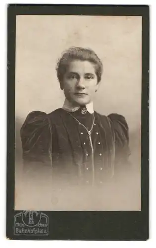 Fotografie Hermann Tietz, München, Bahnhofplatz, Junge Dame mit Zopf, langer Kette und schwarzem Kleid
