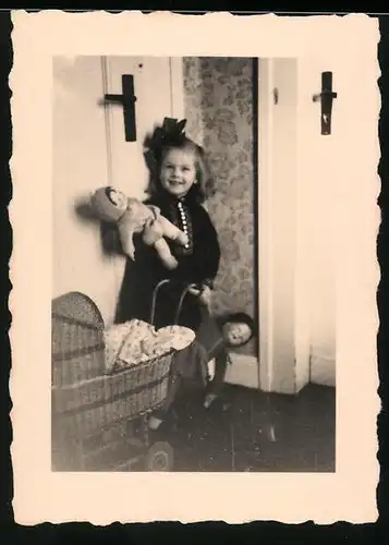 Fotografie lachendes Mädchen mit Puppe und Puppenwagen