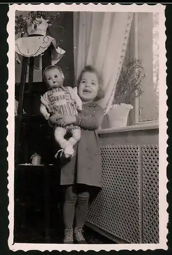 Fotografie lachendes Mädchen spielt mit ihrer Puppe, Doll, Dolly