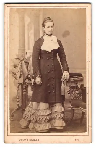 Fotografie Johann Bichler, Steyr, Junge Dame mit Flecht-Dutt im eleganten Rüschenkleid mit Zierschleife