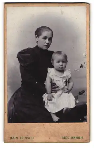 Fotografie Karl Posselt, Ried /Innkreis, Elegante junge Mutter mit Kleinkind auf dem Schoss