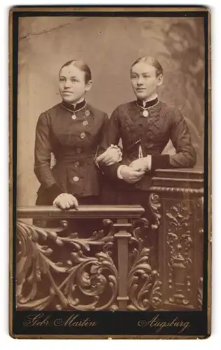 Fotografie Gebr. Martin, Augsburg, Bahnhofstrasse, Zwei junge Schwestern in eleganten Sonntagskleidern mit Medaillons
