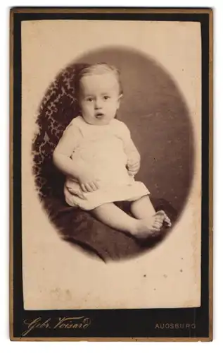 Fotografie Gebr. Voisard, Augsburg, Fuggerstrasse, Baby im Strampelkleid auf einem Sessel