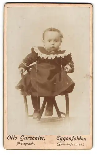 Fotografie Otto Gurschler, Eggenfelden, Bahnhofstrasse, Kleinkind im Kleidchen auf einem Sitz