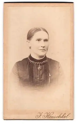 Fotografie J. Heuschkel, Rathenow, Schützen-Str. 6, Dame in schwarzem Kleid mit Halskette und Ohrringen