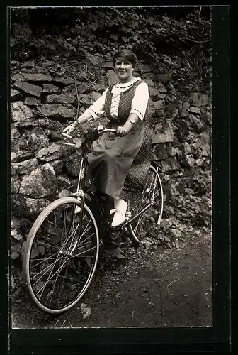 AK Dame im gepunktetem Kleid auf einem Fahrrad