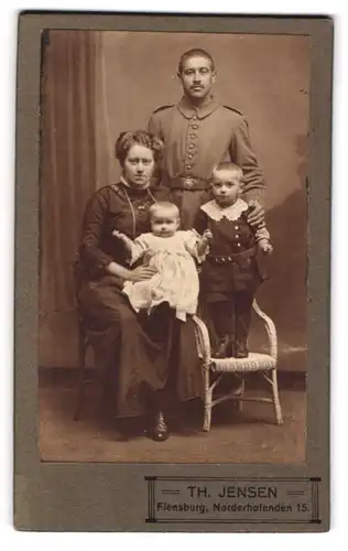 Fotografie Th. Jensen, Flensburg, Norderhofenden 15, Soldat in Uniform im Kreise seiner Familie