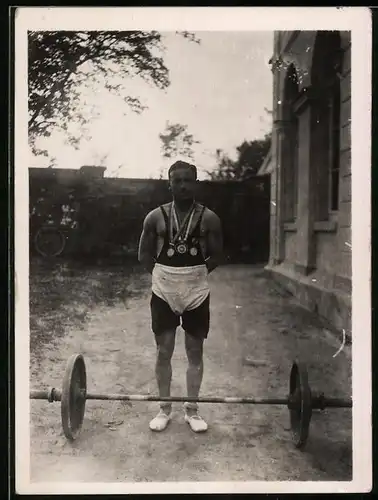 Fotografie Gewichtheber mit Medaillen und Langhantelstange, Weightlifter