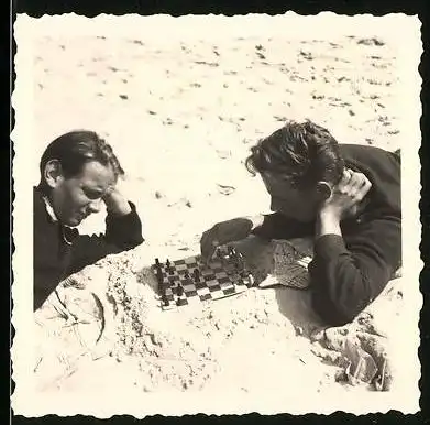 Fotografie Schach - Chess, Burschen mit Reiseschachspiel am Strand