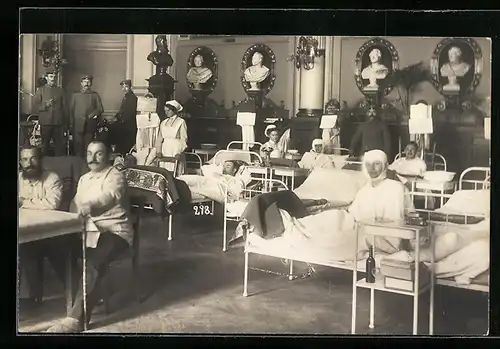 Foto-AK Berlin, Verwundete mit Krankenschwestern in Lazarettsaal mit Gipsbüsten, Rotes Kreuz
