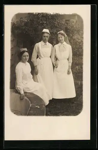 Foto-AK Drei Krankenschwestern in einem Garten, Rotes Kreuz
