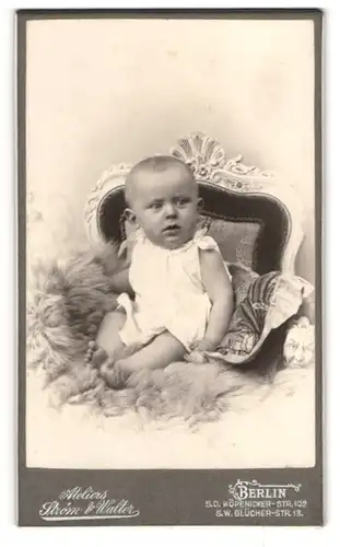 Fotografie Stóm & Walter, Berlin, Köpenicker-Str. 102, Süsses Kleinkind im Hemd sitzt auf einem Fell