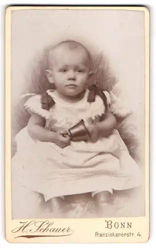 Fotografie Heinrich Schauer, Bonn, Franziskanerstr. 4, Süsses Kleinkind im Kleid mit Glocke