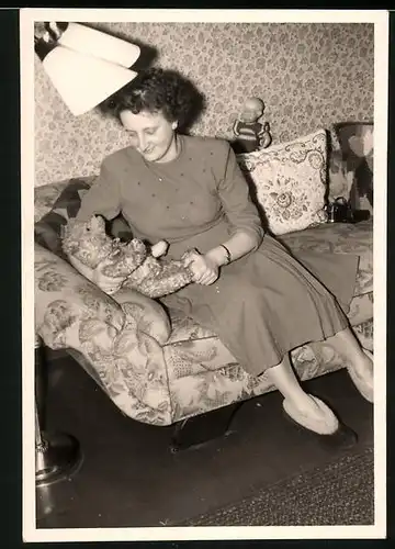 Fotografie Dame mit Teddy, Teddybär und Puppe auf dem Sofa sitzend