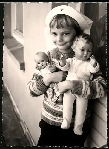 Fotografie Winterhagen, Solingen, Mädchen mit Rot kreuz Krankenschwester-Haube und Puppen im Arm
