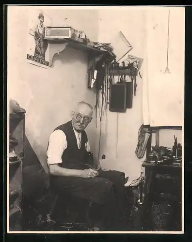 Fotografie Schuhmacher in seiner Werkstatt bei der Arbeit