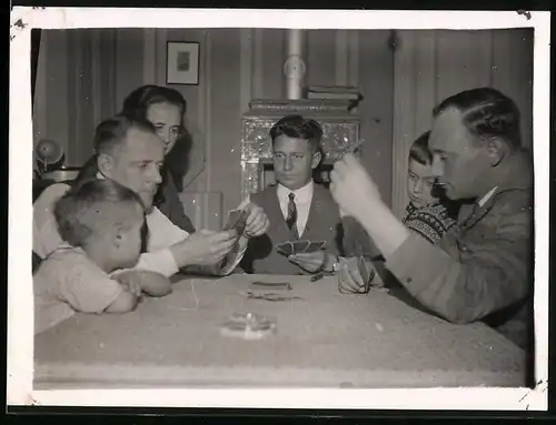 Fotografie Familie beim Kartenspiel am Esstisch