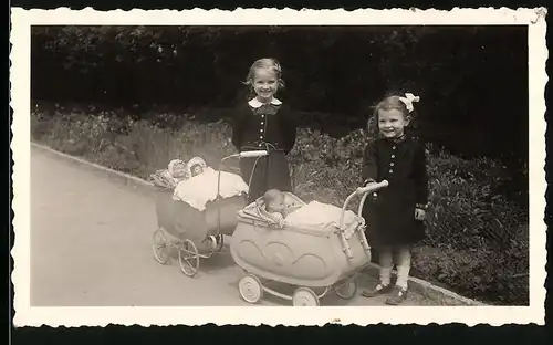 Fotografie lächelnde Mädchen mit Puppen im Puppenwagen