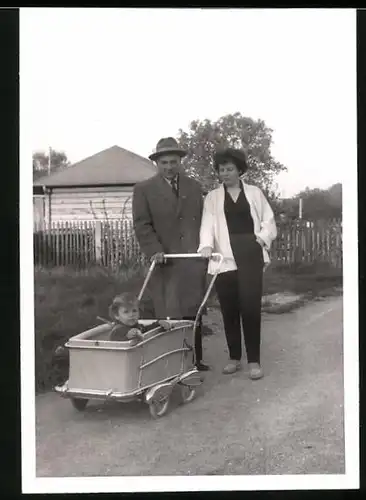 Fotografie Elternpaar schiebt Kinderwagen